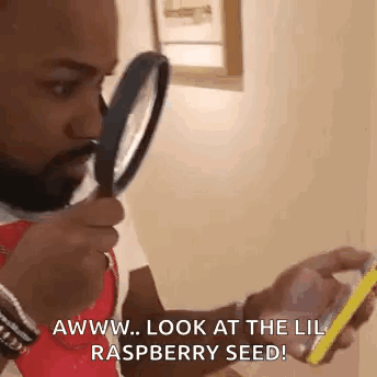 Man Holding Magnifying Glass Looking at Phone