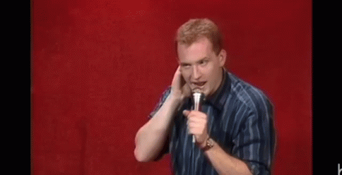 Man Holding Microphone Making Funny Face Red Background