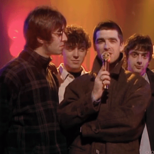 Man Holding Microphone Next to Two Men