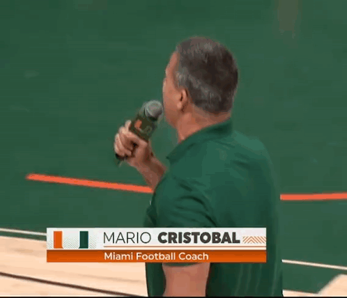 Man Holding Microphone With Name Mario Cristobal