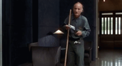 Man Holding Mop in Hallway