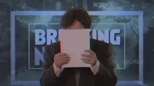 Man Holding Paper in Front of Breaking News Sign