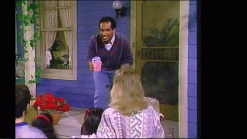 Man Holding Present at Blue House