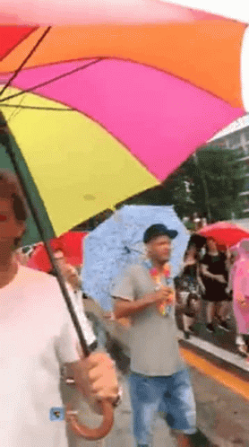 Man Holding Rainbow Umbrella Walking