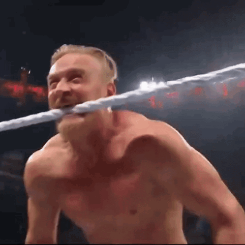 Man Holding Rope in Mouth in Wrestling Ring