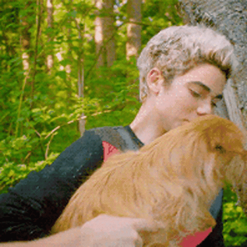 Man Holding Small Dog In Woods GIF