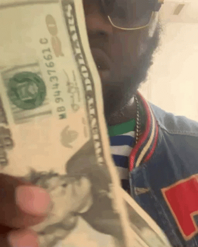 Man Holding Stack Of Money With Bill Saying NB943736610 GIF