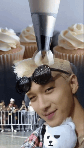 Man Holding Stuffed Animal Near Frosted Cupcakes