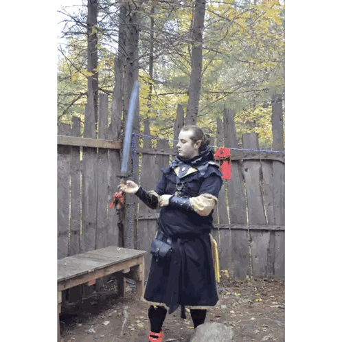Man Holding Sword in Woods