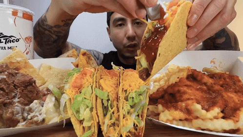 Man Holding Taco in Front of Del Taco
