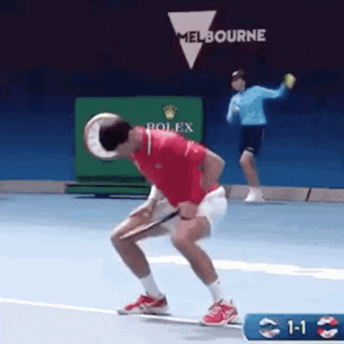 Man Holding Tennis Racquet as Another Throws Ball