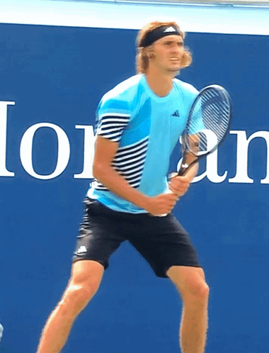 Man Holding Tennis Racquet at Lozan Sign