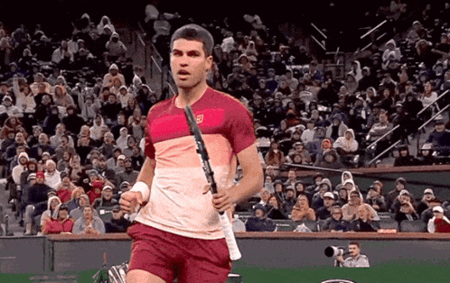 Man Holding Tennis Racquet in Front of Crowd