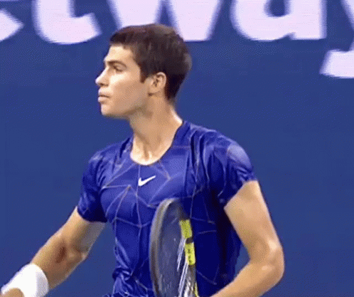 Man Holding Tennis Racquet In Front Of Localiza Sign GIF
