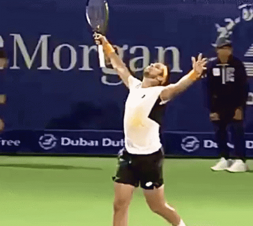 Man Holding Tennis Racquet In Front Of Morgan Sign GIF