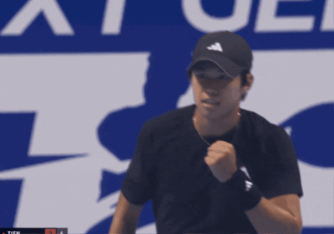 Man Holding Tennis Racquet In Front Of Ticu Sign GIF