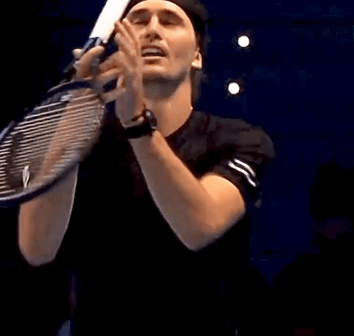 Man Holding Tennis Racquet in Mouth