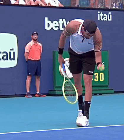 Man Holding Tennis Racquet on Court with BETV Ad