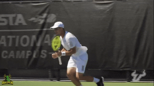 Man Holding Tennis Racquet on Court With Bullpen Logo