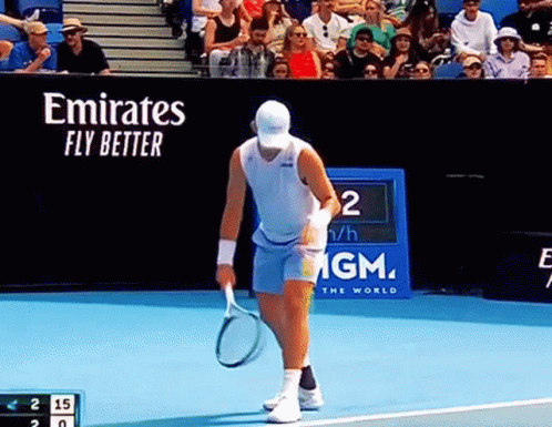 Man Holding Tennis Racquet on Court with Emirates Fly Better Banner