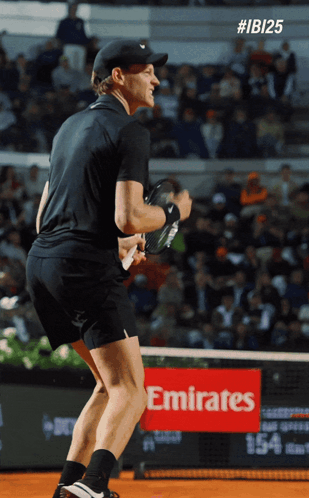 Man Holding Tennis Racquet On Court With Emirates Sign GIF