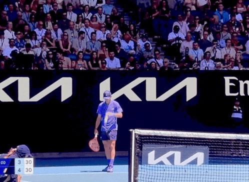 Man Holding Tennis Racquet On Court With Kia Sign