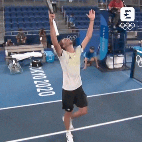 Man Holding Tennis Racquet on Court With Tokyo 2020
