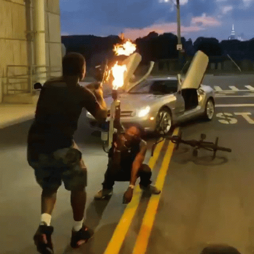 Man Holding Torch in Front of Car With ST on Side