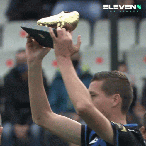 Man Holding Trophy Behind Eleven Pro League Logo