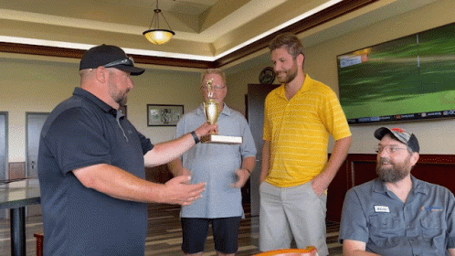 Man Holding Trophy Talking To Two Men GIF