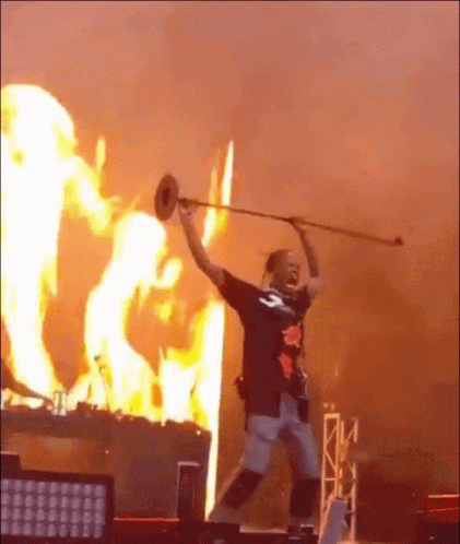 Man Holding Trumpet in Front of Fire