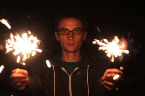 Man Holding Two Sparklers GIF