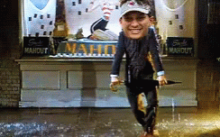 Man Holding Umbrella in Front of Maho Sign