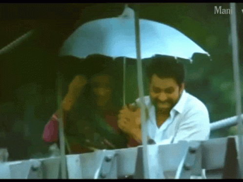 Man Holding Umbrella Over Woman Saying Man