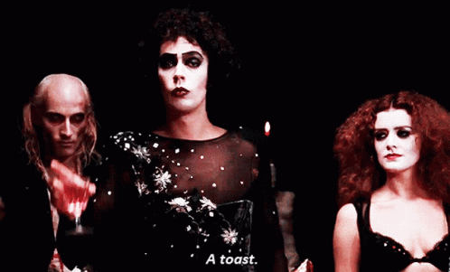 Man Holding Wine Glass Says A Toast Next To Two Women GIF