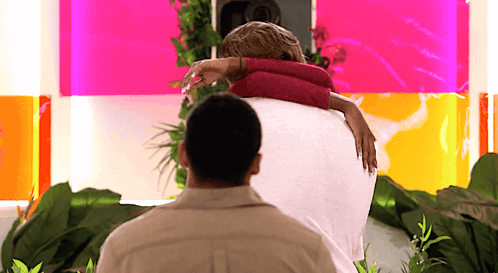 Man Holding Woman in Front of Pink Wall