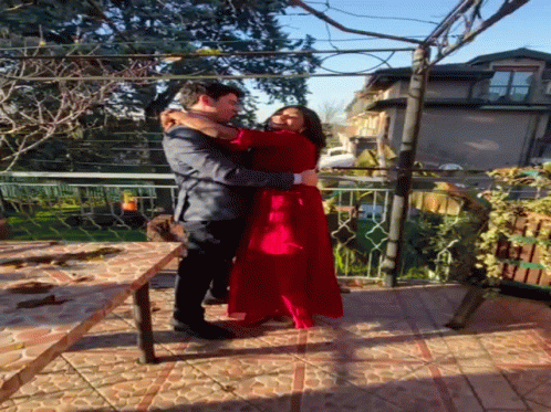 Man Holding Woman in Red Dress