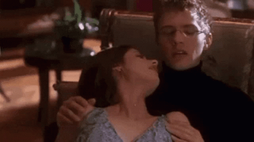 Man Holding Woman's Neck in Chair