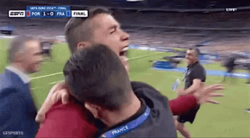 Man Hugging Another Man on Soccer Field