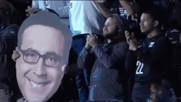 Man in 22 Jersey Holding Man Face Cutout