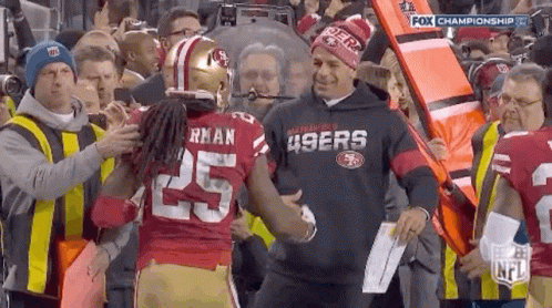 Man in 49ers Sweatshirt Shaking Hands With Football Player