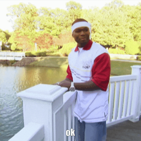 Man in 50 Cent Shirt on Railing Overlooking Lake