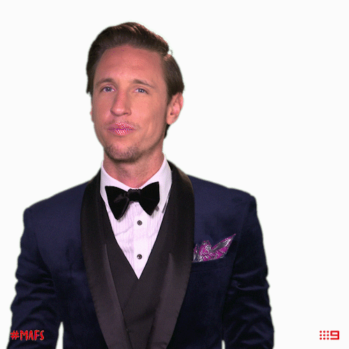 Man In A Suit Smiling Shoulder Brush GIF