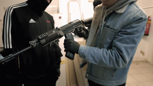 Man In Adidas Jacket Holding Rifle GIF