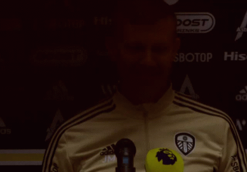 Man in Adidas Jacket in Front of Boost Drinks Sign