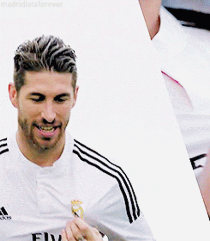 Man in Adidas Shirt Smiling Holding Something