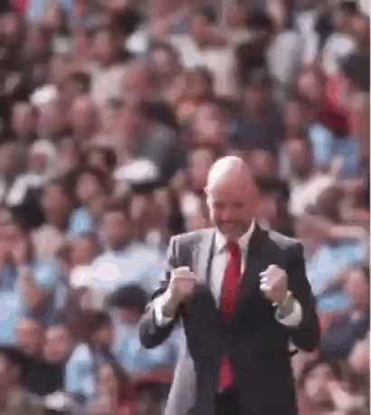 Man In Adidas Shirt Smiling In Front Of Emirates Ads GIF