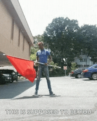 Man In Aero Shirt Holding Red Flag GIF