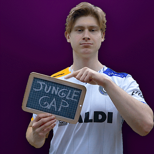 Man in Aldi Shirt Holding Chalkboard Saying Jungle Gap
