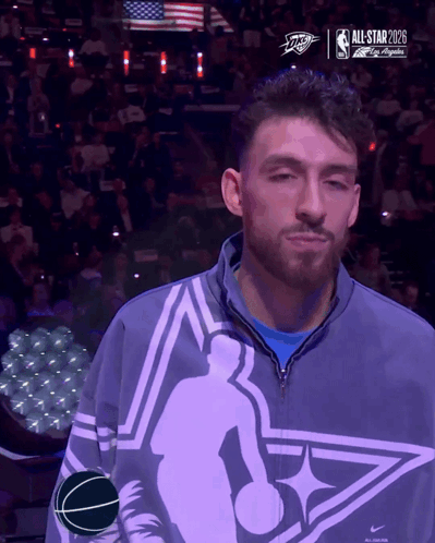 Man in All Star Jacket in Front of Screen